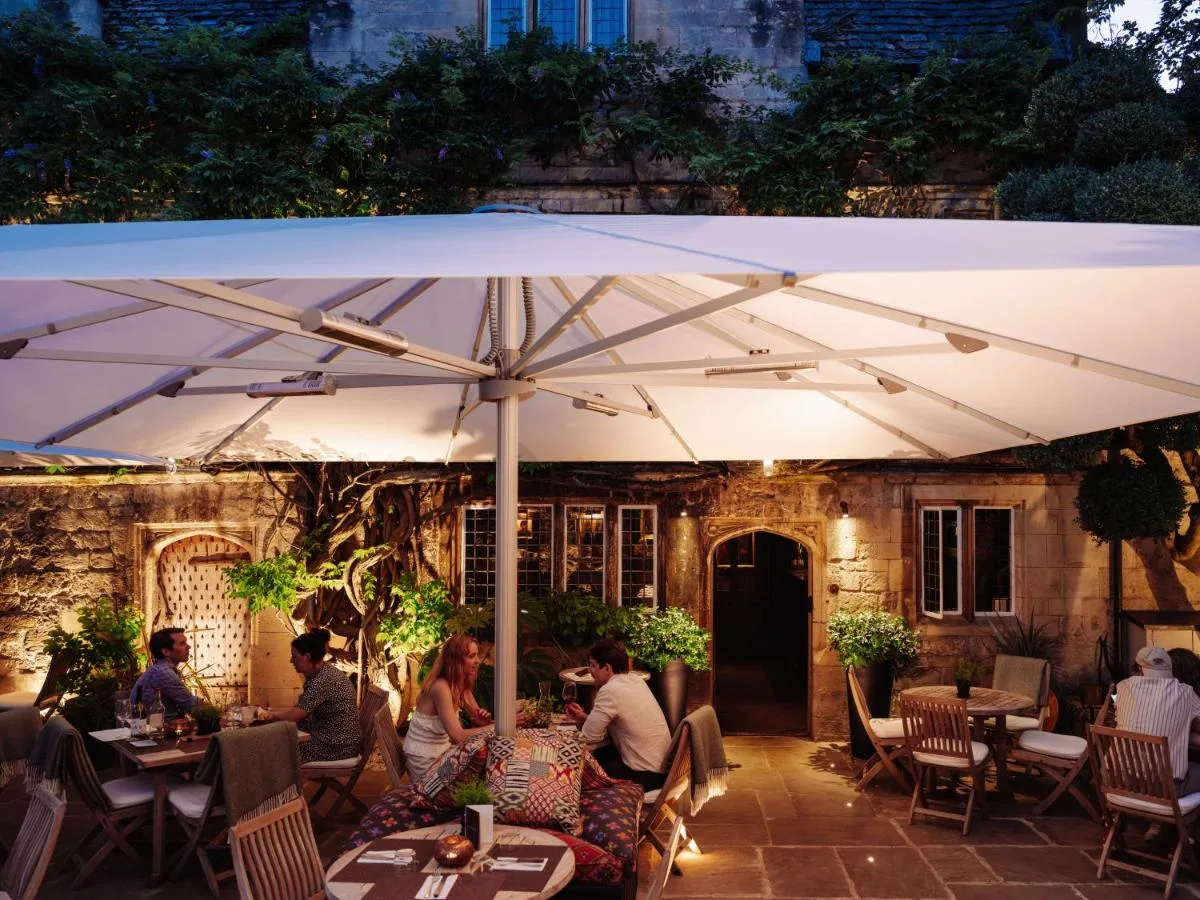 Guests dining under an umbrella at Old Parsonage Hotel on Banbury Road, Oxford